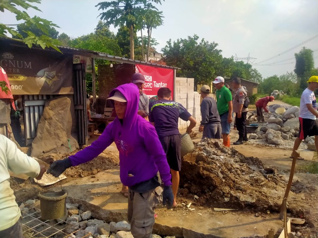 Bhabinkamtibmas dan Babinsa Desa Sangiang Rancaekek bersama warga kerja bakti perbaikan jalan