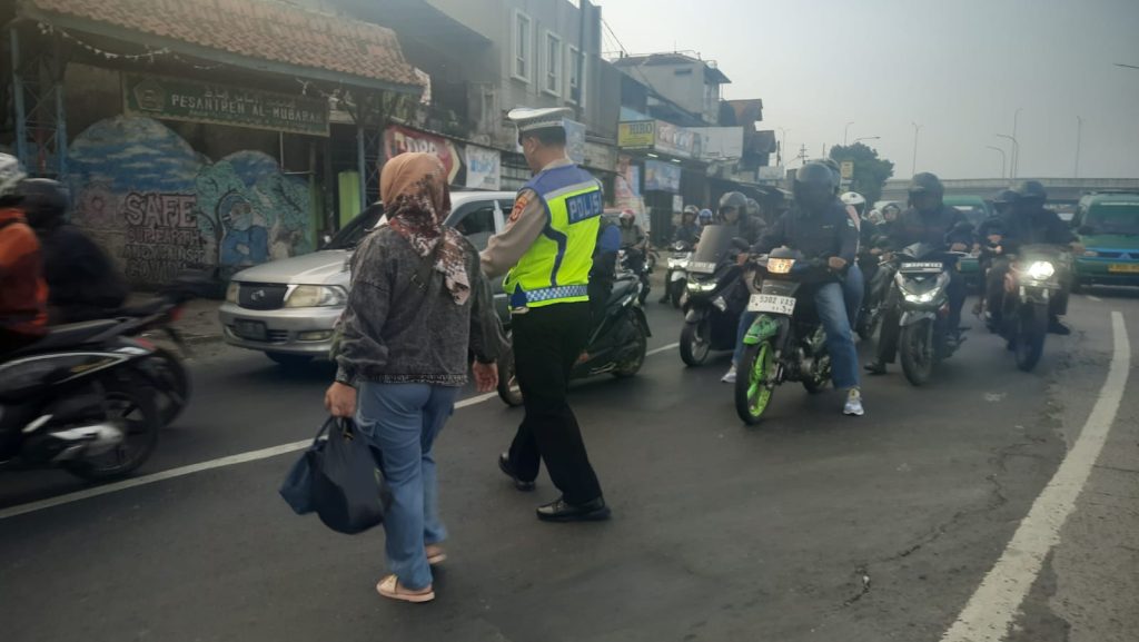 Jaga Keselamatan, Anggota Lantas Atur Lalin dan Bantu Pejalan Kaki menyebrang Jalan