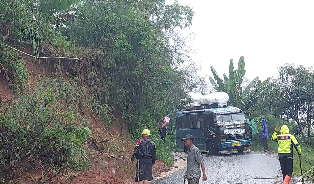 Polsek Banjarwangi Bersama Warga Bersihkan Jalan dari Material Longsor Saat Patroli